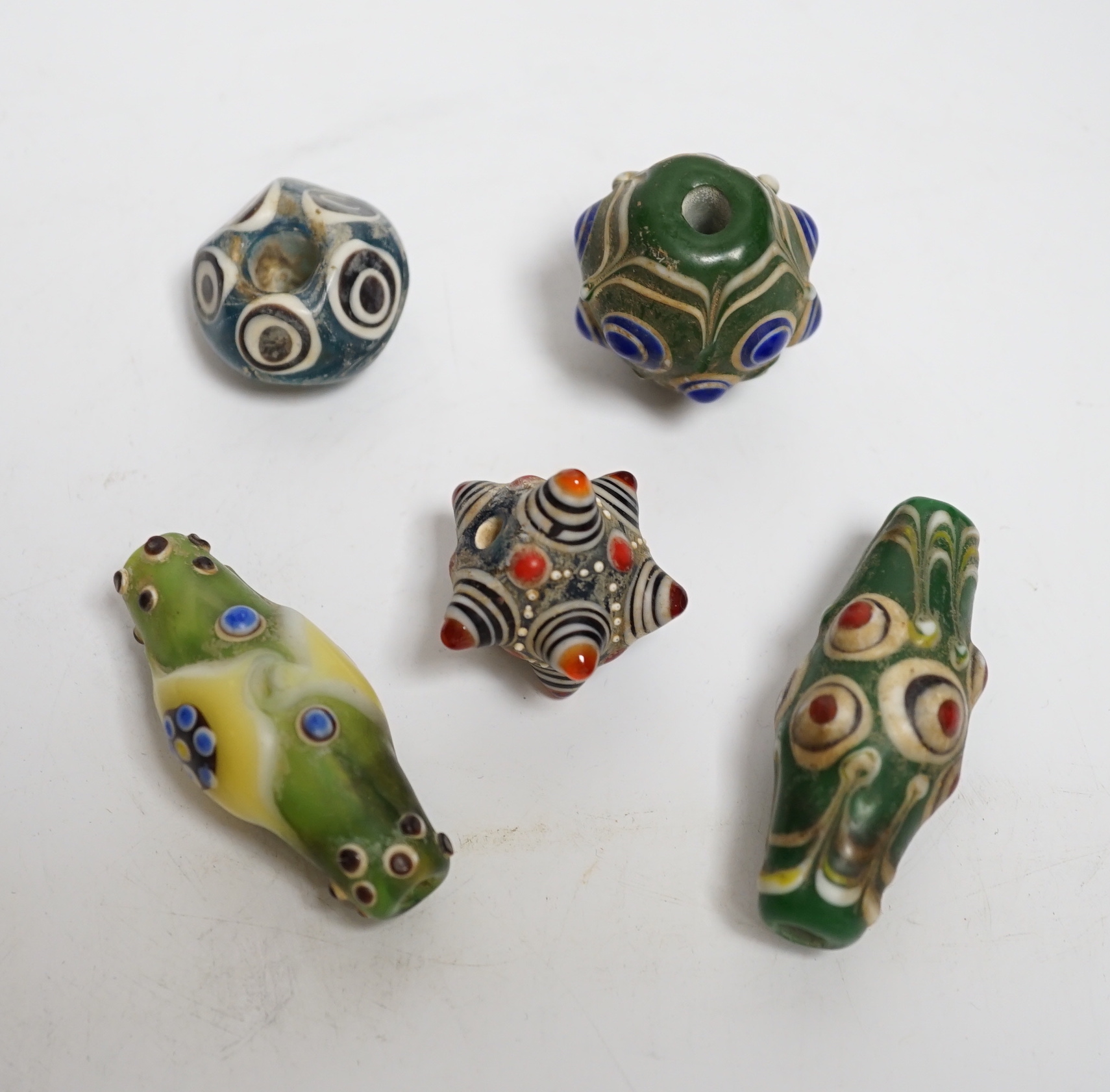 Five Eastern glass beads, largest 5.5cm long